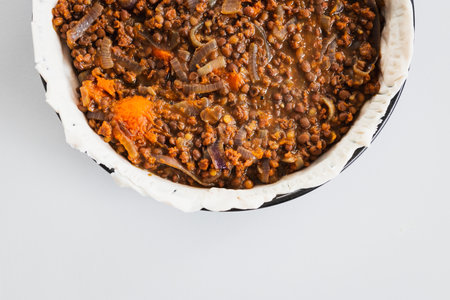 plant-based lentil and pumpkin pie with filling just poured into the pastry before cooking it, healthy vegan food recipesの写真素材