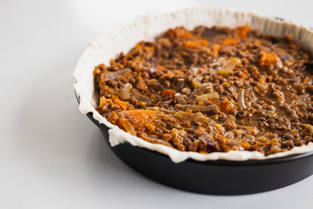plant-based lentil and pumpkin pie with filling just poured into the pastry before cooking it, healthy vegan food recipesの写真素材