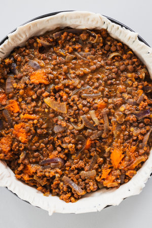 plant-based lentil and pumpkin pie with filling just poured into the pastry before cooking it, healthy vegan food recipesの写真素材