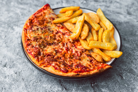 plate with half pizza half chips, concept of fast food or unhealthy caloric foodの写真素材