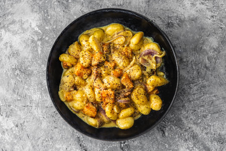 turmeric gnocchi with pumpkin and onion in creamy sauce, healthy plant-based food recipesの写真素材