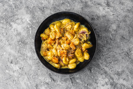 turmeric gnocchi with pumpkin and onion in creamy sauce, healthy plant-based food recipesの写真素材