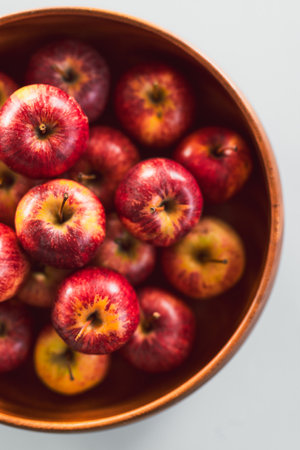 plenty of red apples in big wooden fruit bowl on kitchen countertop, concept of simple natural healthy ingredientsの写真素材