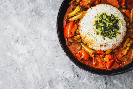 vegetable curry with rice dome in the middle topped with coriander, healthy vegan food recipesの写真素材