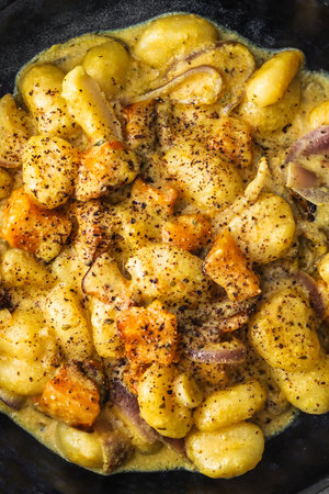 turmeric gnocchi with pumpkin and onion in creamy sauce, healthy plant-based food recipesの写真素材