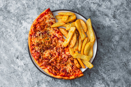 plate with half pizza half chips, concept of fast food or unhealthy caloric foodの写真素材