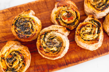 pumpkin spinach and cheese pastry rolls on wooden cutting board, freshly baekd and homemade, healthy food recipesの写真素材
