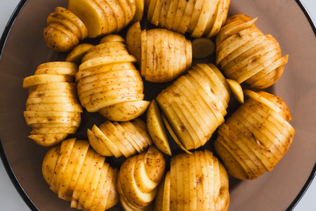 plant-based hasselback potatoes about to go in the oven, healthy vegan food recipesの写真素材