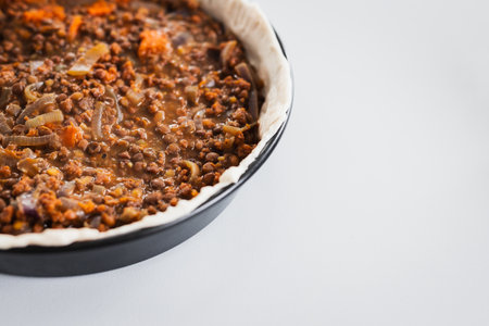plant-based lentil and pumpkin pie with filling just poured into the pastry before cooking it, healthy vegan food recipesの写真素材