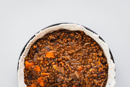 plant-based lentil and pumpkin pie with filling just poured into the pastry before cooking it, healthy vegan food recipesの写真素材