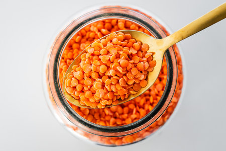 pantry staple close-up, spoonful of red lentils over clear glass jar shot from above, daily ingredientsの写真素材