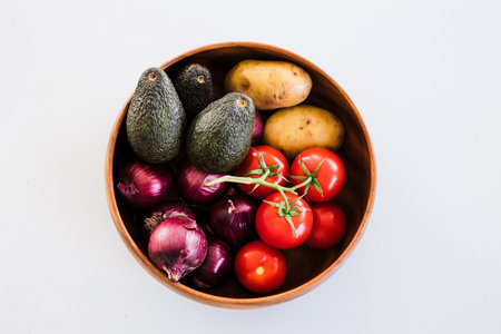 fruit bowl with tomatoes potatoes avocados and red onions, concept of simple natural healthy ingredientsの写真素材