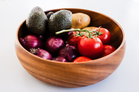 fruit bowl with tomatoes potatoes avocados and red onions, concept of simple natural healthy ingredientsの写真素材