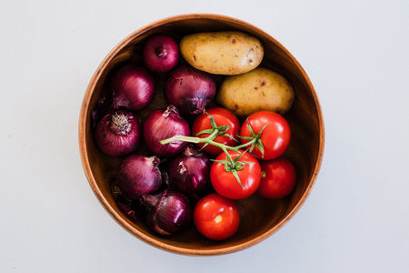 fruit bowl with tomatoes potatoes and red onions, concept of simple natural healthy ingredientsの写真素材