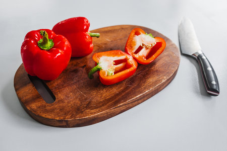fresh red bell peppers on wooden chopping board, concept of simple natural healthy ingredientsの写真素材