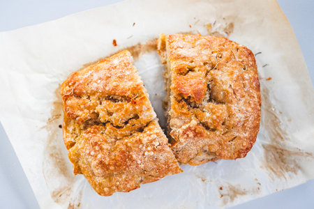 homemade bread cut in half on baking paper, concept of simple natural healthy ingredients