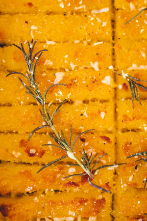 crispy golden polenta chips with rosemary roasted in the oven on a tray, delicious and homemadeの写真素材