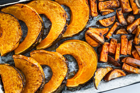 roasted sliced kent pumpkin and sweet potato chips on an oven tray, simple healthy ingredientsの写真素材