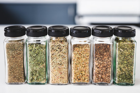 glass jars filled with dried herbs,  kitchen organization or cooking and pantry lifestyle themesの写真素材