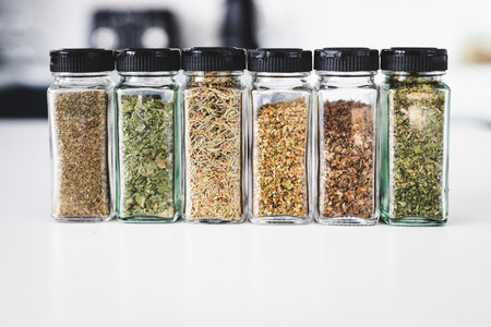 glass jars filled with dried herbs,  kitchen organization or cooking and pantry lifestyle themesの写真素材