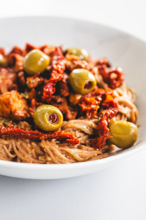 a nourishing bowl of soba noodles topped with teriyaki tofu chunks, sundried tomatoes and green olives â ideal for healthy, plant-based, and prediabetes-friendly mealsの写真素材