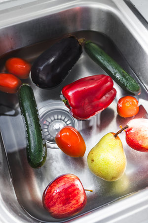 mixed fruits and vegetables soaking in bicarb soda in sink to remove pesticidesの写真素材
