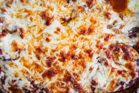 rustic homemade vegetarian eggplant parmigiana with cheese and lentil ragout in oven tray on kitchen counter, a wholesome mediterranean style mealの写真素材