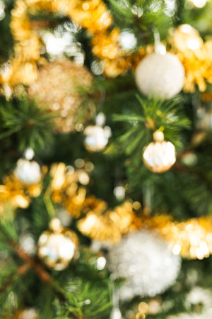 blurred christmas background with golden and silver decorations and festive bokeh, concept of soft seasonal texture for holiday graphics and cozy winter celebration atmosphereの写真素材