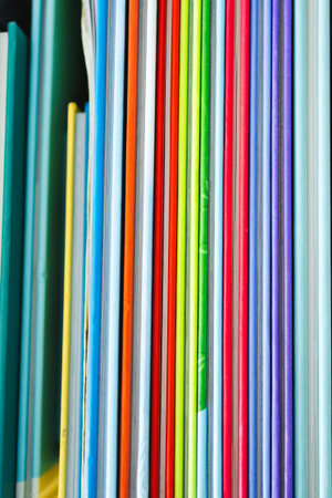 colorful children's books  on bookshelf shot from above with shallow depth of field, representing...