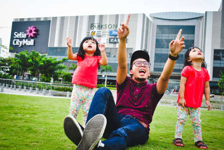 Young man and twins having fun at the parkの素材