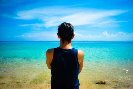 Young man facing the ocean