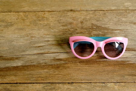 Selective focus of Fancy colorful sunglasses for kids on wooden background with copy space.の写真素材