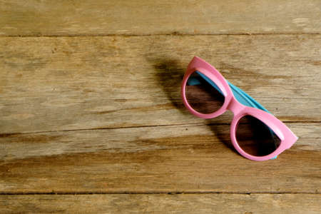 Selective focus of Fancy colorful sunglasses for kids on wooden background with copy space.の写真素材