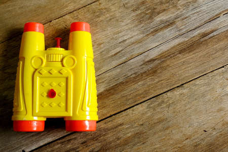 Selective focus of binocular type of water gun toys on wooden background with copy space.の写真素材