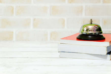 Selective focus of ring bell and stack of books isolated with copy space for text.の写真素材