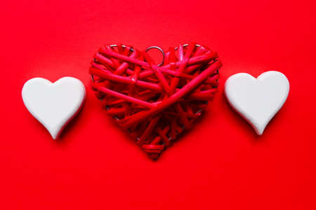 Top view of red and white wooden handcraft heart symbol on red background.  Valentine's day theme.