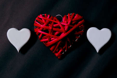 Top view of red and white wooden handcraft heart symbol on black background. Dark,elegance and luxury backdrop. Valentine's day theme.の写真素材