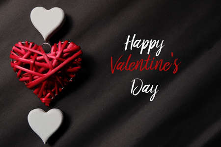 Top view of red and white wooden handcraft heart symbol on black background written with 'HAPPY VALENTINE'S DAY'. Dark,elegance and luxury backdrop. Valentine's day theme.の写真素材