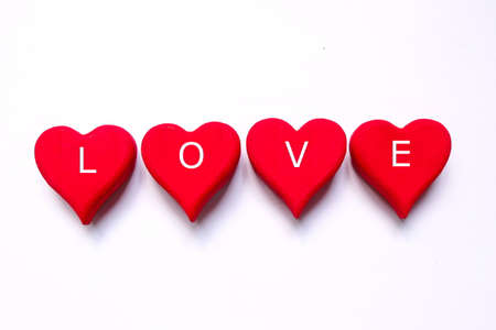 Top view of red wooden handcraft heart symbol written with 'LOVE' on white background. Valentine's day theme.の写真素材