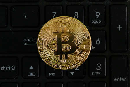Golden bitcoin replica on a black numerical keyboard. Business and finance concept.の写真素材