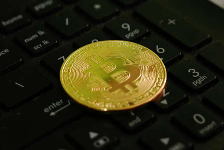Golden bitcoin replica on a black numerical keyboard. Business and finance concept.の写真素材