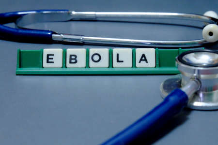 Selective focus of Stethoscope and letter of Ebola on grey background. Healthcare and Medical...