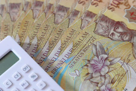 Close up view of Brunei Darussalam bank note. Money with calculator. Dollar.