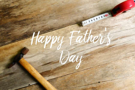Happy father's day concept. Hammer and measuring tape on wooden background.の写真素材