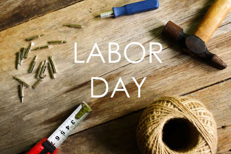 Labor day concept.Screw,nut,measuring tape,hammer and rope on wooden background.の写真素材