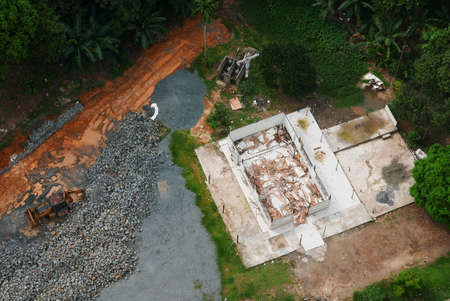 Top view or aerial view of demolished building and construction area with an excavator.