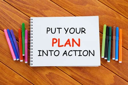 Advice and motivation. Top view of colorful pen and notebook written with Put Your Plan Into Action...