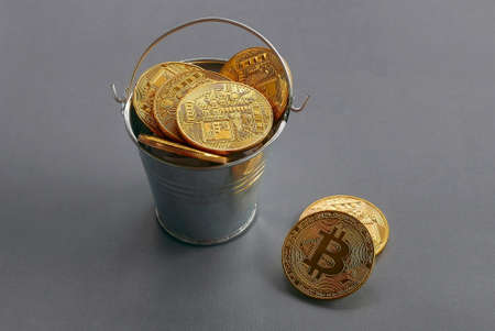 Golden replica bitcoin with pile on grey background. Business and finance concept.の写真素材