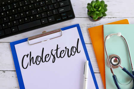 Top view of plant,books,stethoscope,keyboard,pen,clipboard and paper written with Cholesterol.の写真素材