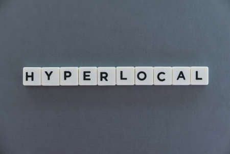 Hyperlocal word made of square letter word on grey background.の写真素材